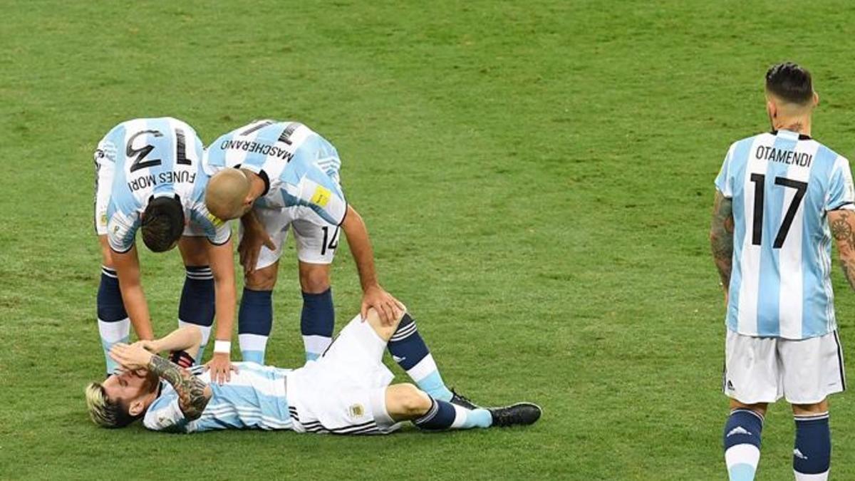 Mascherano ayuda a Messi, tendido en el suelo