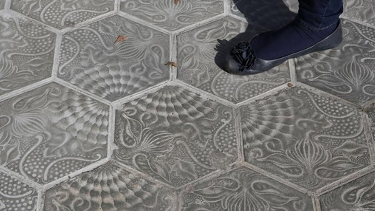 Baldosas mal colocadas en la acera del paseo de Gràcia, en la esquina de la calle Aragó delante de la tienda Desigual.