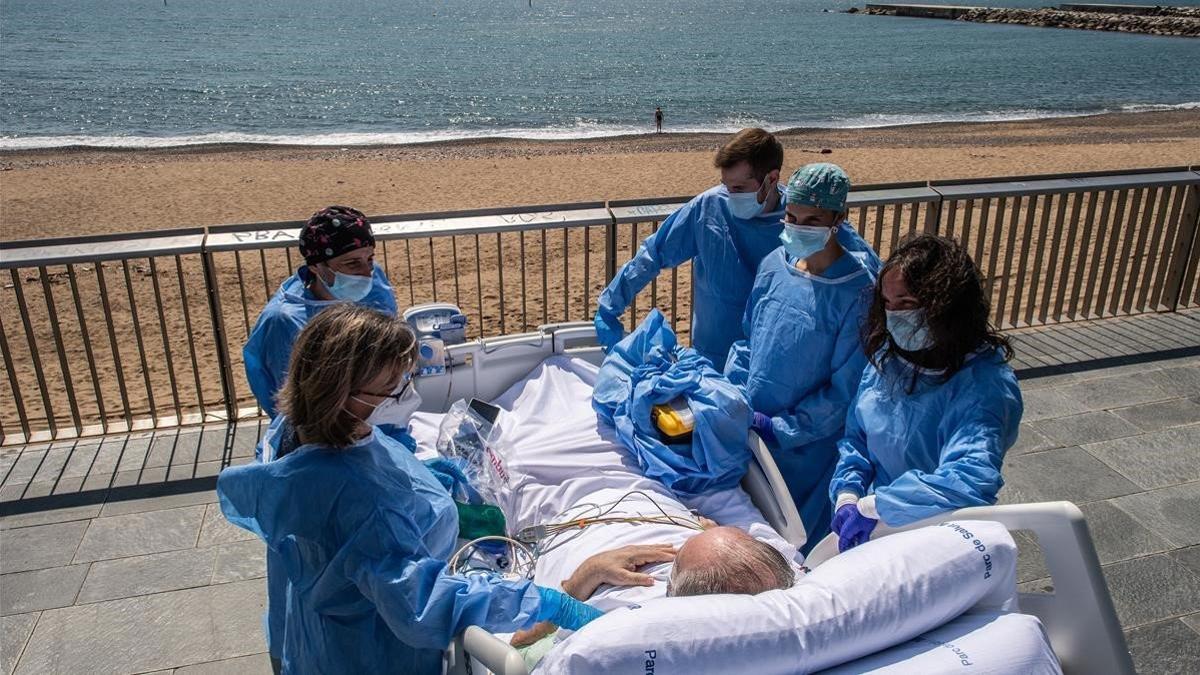 Isidre Correa, junto a su mujer y el equipo médico, frente a la playa delante del Hospital del Mar de Barcelona