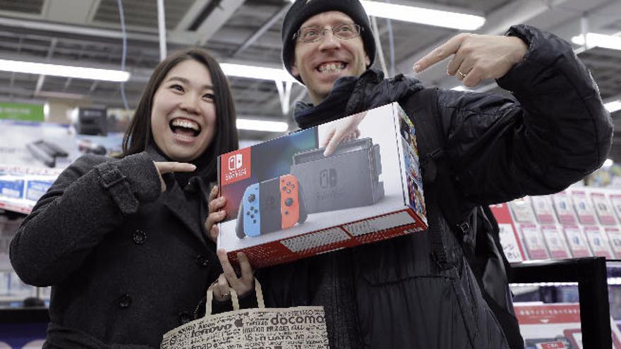 Una pareja muestra la nueva consola Nintendo Switch, ayer en un comercio de Tokio.