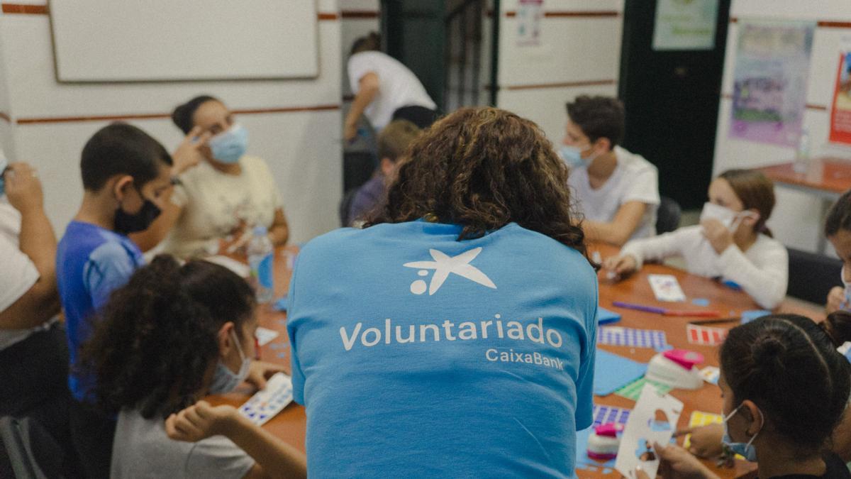 Una voluntaria de CaixaBank, con varios niños durante una actividad.