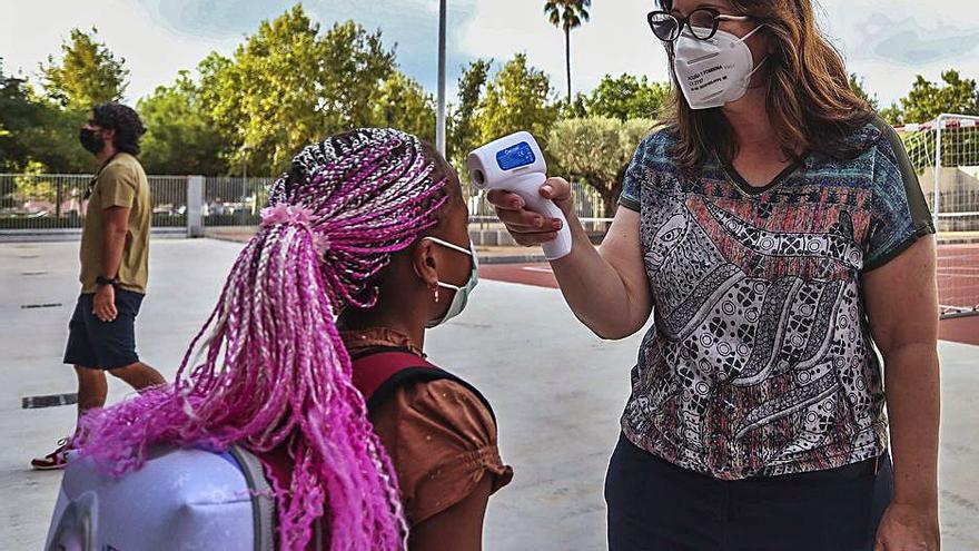 Una profesora toma la temperatura a una alumna. | FRANCISCO CALABUIG