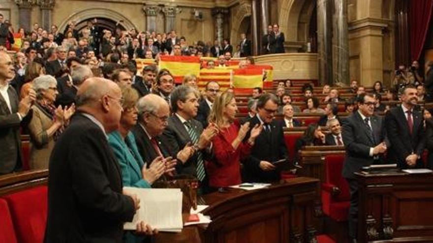 Els diputats de JxSí i la CUP, i el Govern aplaudeixen en peu, mentre els diputats del PPC mostren banderes espanyoles i catalanes, i els diputats de PSC i C&#039;s resten seguts, després de l&#039;aprovació de la resolució independentista