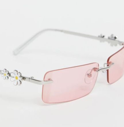 Gafas de sol con montura al aire estilo años 90 con lentes rosas y charms de margaritas en las patillas de ASOS DESIGN
