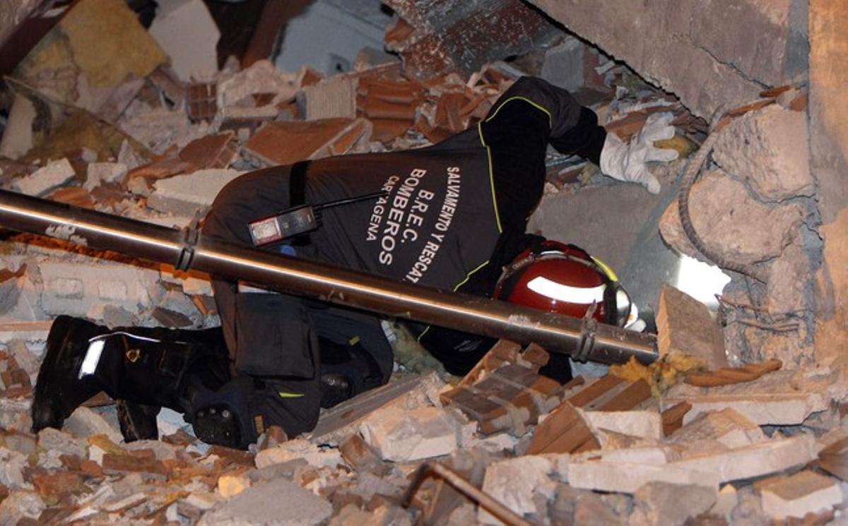 Un bomber busca entre la runa d’un edifici derruït pel terratrèmol, dijous a la matinada, a Llorca.