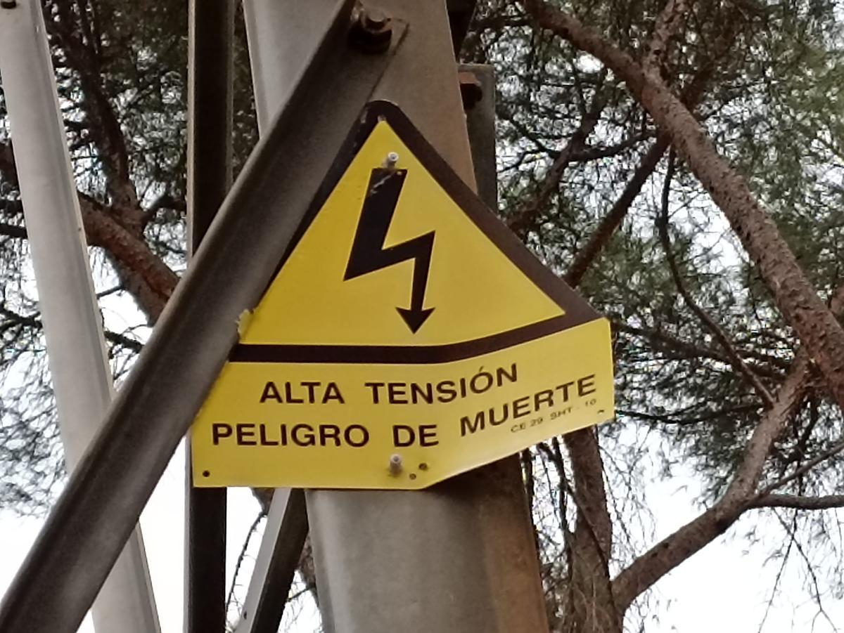 Cartel de aviso en una torre de electricidad. 