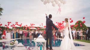 Los invitados reciben a los novios de una boda alrededor de una piscina.