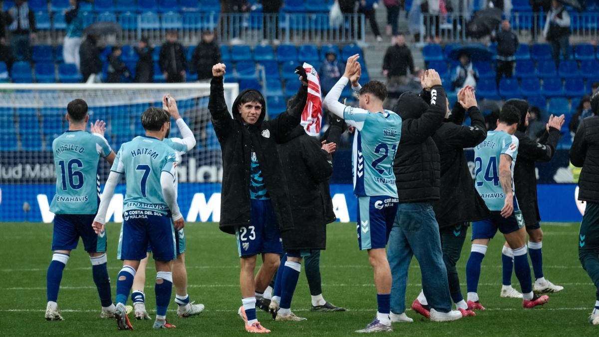 Los jugadores del Málaga CF celebran con la afición la victoria ante el Almería.