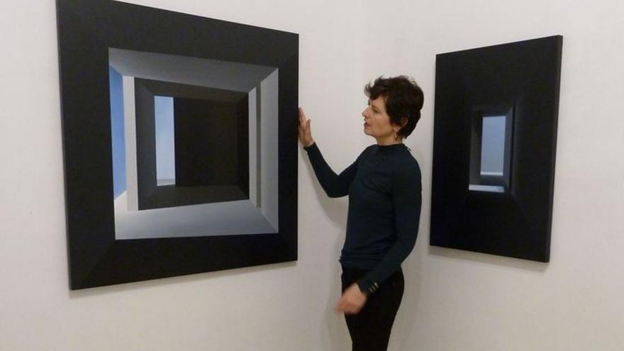 Por la izquierda, Mónica Dixon, entre dos cuadros de interiores de «Luz distante»; sus esculturas en forma de casitas, y uno de sus nuevos paisajes.