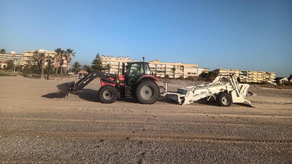 Trabajos de cribado y nivelación en la playa.