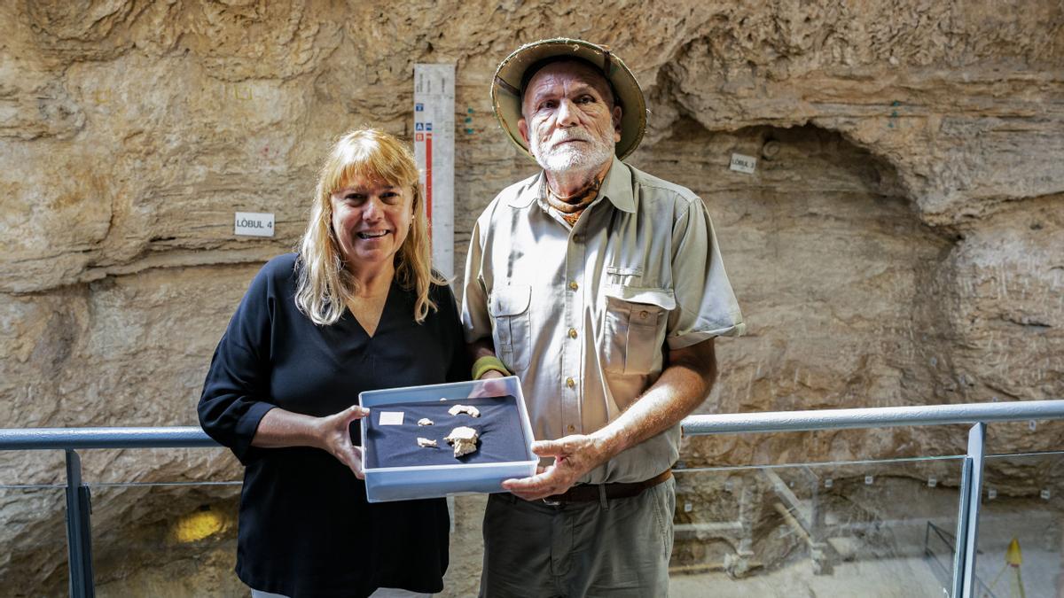 Natalia Garriga Ibánez, consejera de Cultura de la Generalitat de Catalunya, y Eudald Carbonell Roura, codirector del yacimiento de Capellades, posan juntos con los restos del cráneo de un neandertal encontrados en el yacimiento del Abrigo Romero en Capellades (Anoia).