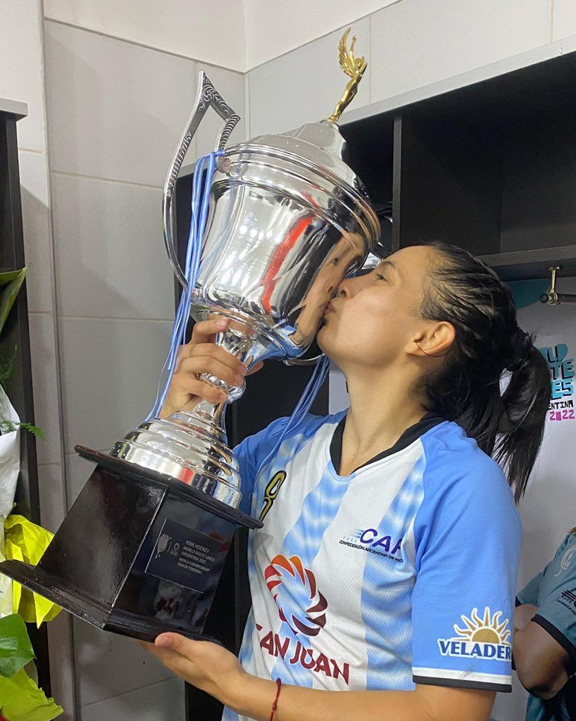 Adriana Soto besa la copa de campeona del mundo.