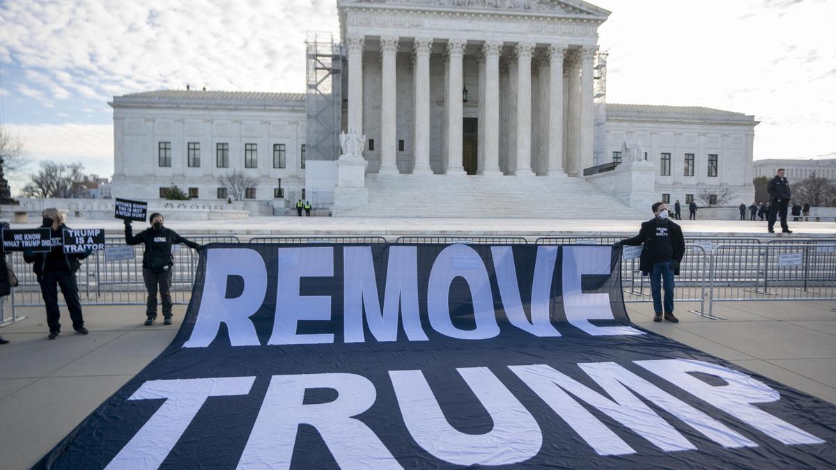Un grupo de manifestantes despliega un cartel que pide sacar a Trump de la carrera electoral, este jueves frente al Tribunal Supremo.