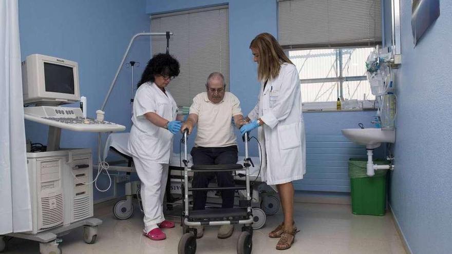 Una doctora y una enfermera de la unidad de Neurorrehabilitación ayudan a un paciente. // Cristina Graña