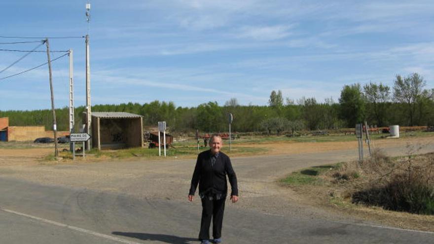 Una vecina cruza la carretera en la que sitúa el solar del futuro velatorio.