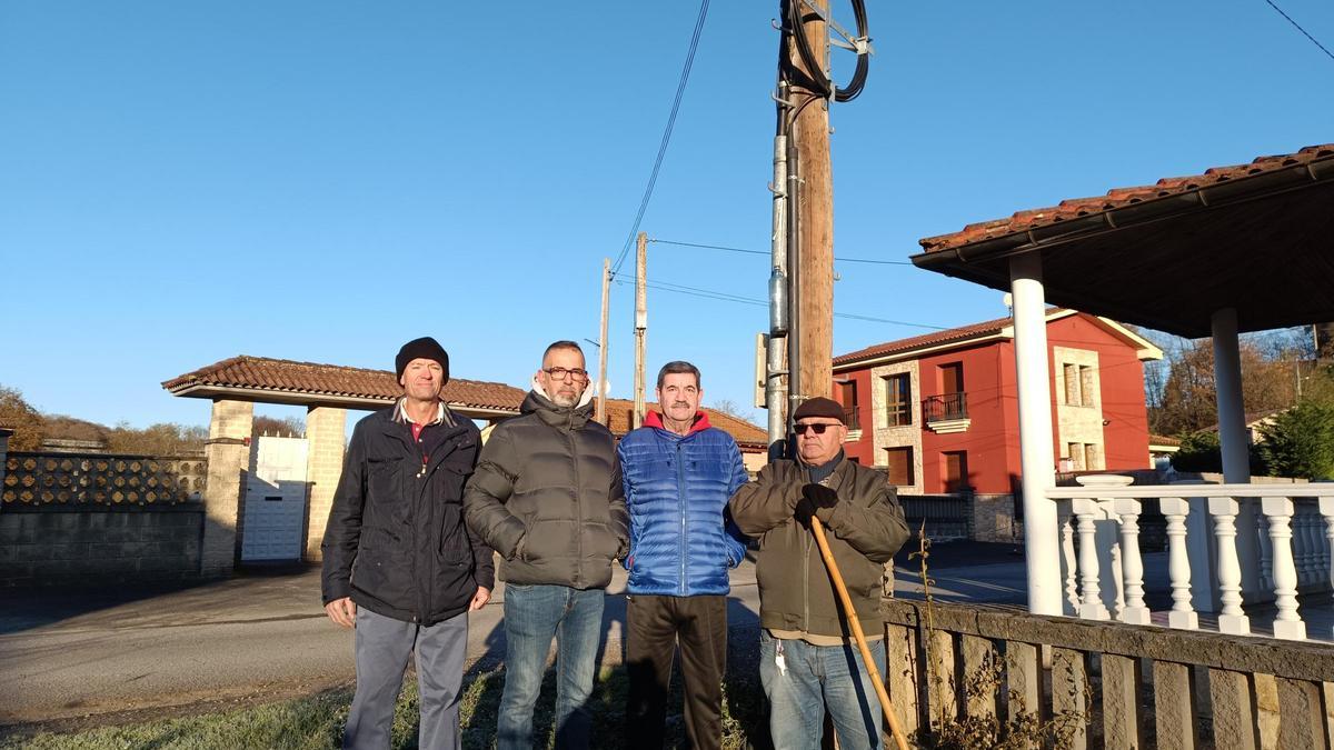 Por la izquierda, Martín Martínez, Pablo González, Juan Ortega y Laudelino Somonte, vecinos de Bendición, al lado del poste donde cuelgan los cables de fibra óptica.