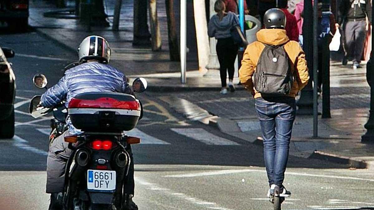 Un patinete eléctrico circula por el lado derecho de la calzada, en una zona permitida para ello.