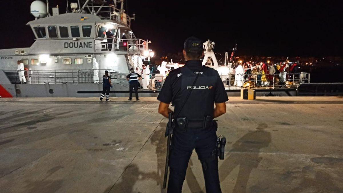 Ein Polizist überwacht die Ankunft irregulärer Migranten im Hafen von Palma.