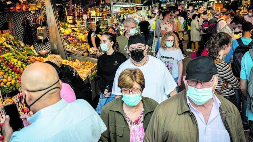 Clientes con mascarilla en el interior del mercado municipal de la Boqueria, en Barcelona. | | MANU MITRU