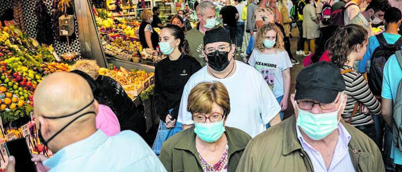 Clientes con mascarilla en el interior del mercado municipal de la Boqueria, en Barcelona.