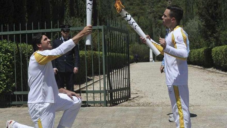 Lefteries Petrounias da el relevo de la antorcha a Giovani Gavio.