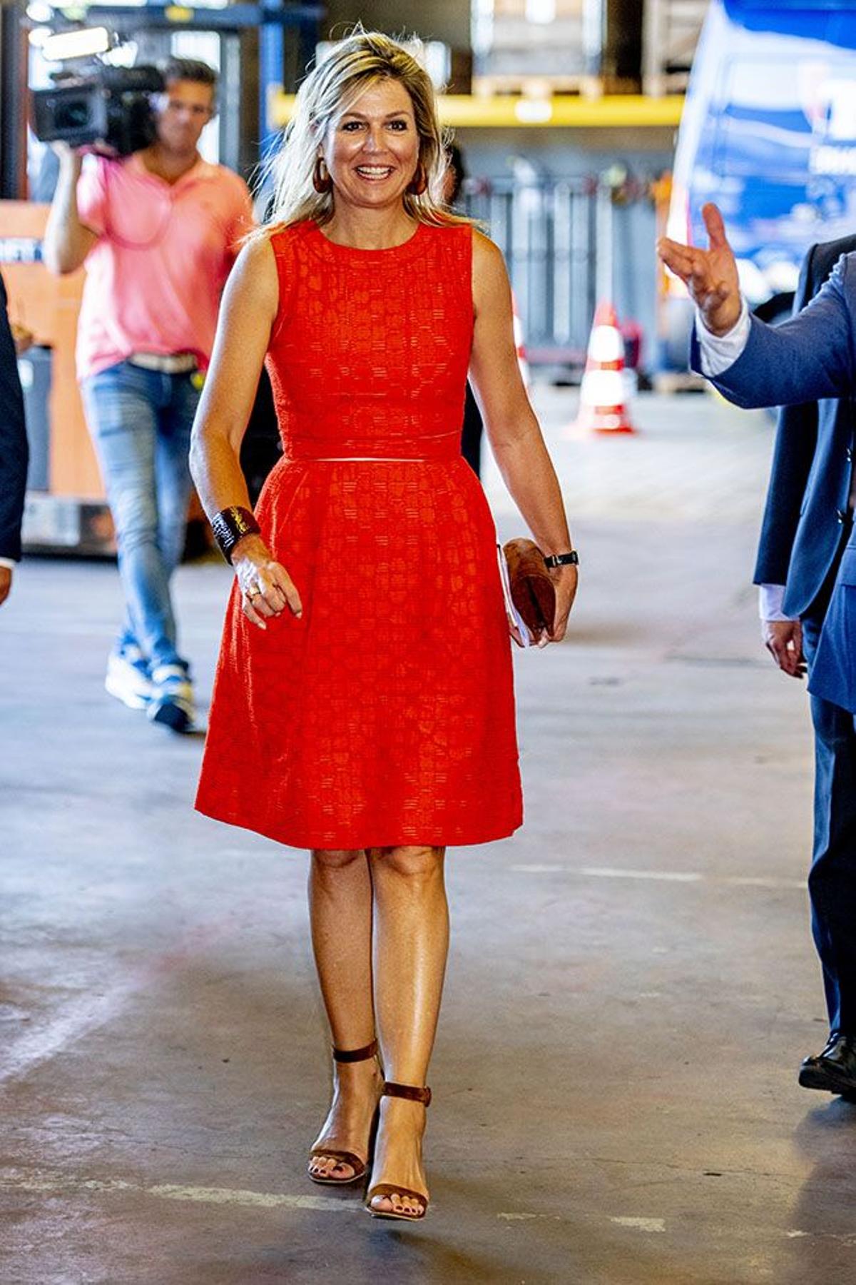 La reina Máxima de Holanda con vestido naranja sin mangas y sandalias al tobillo