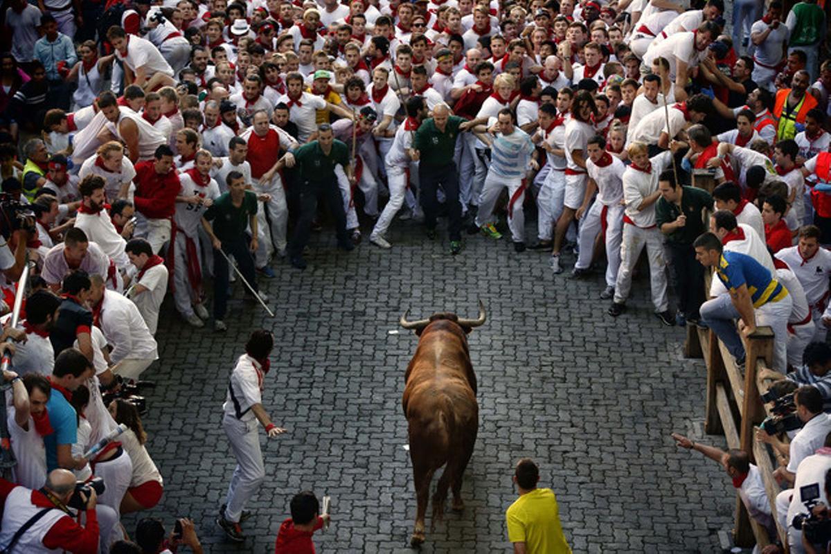 Un toro de la ramaderia Alcurrucén es prepara per córrer rere els mossos, en el primer ’encierro¿ dels ’sanfermines¿. (AP / DANIEL OCHOA DE OLZA)