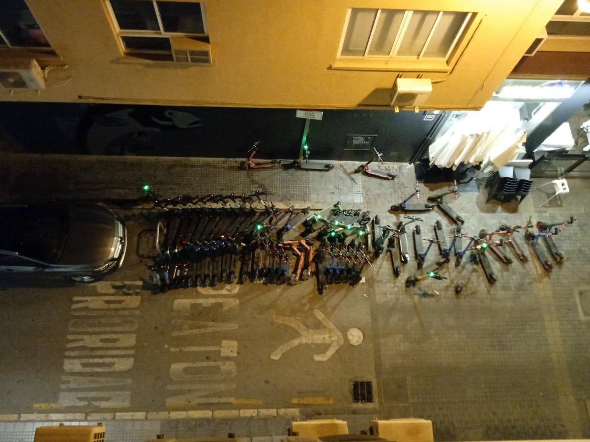 Vista del punto de recogida y estacionamiento, con patinetes por las acera y fuera de su zona, desde un bloque de calle Martínez Campos.