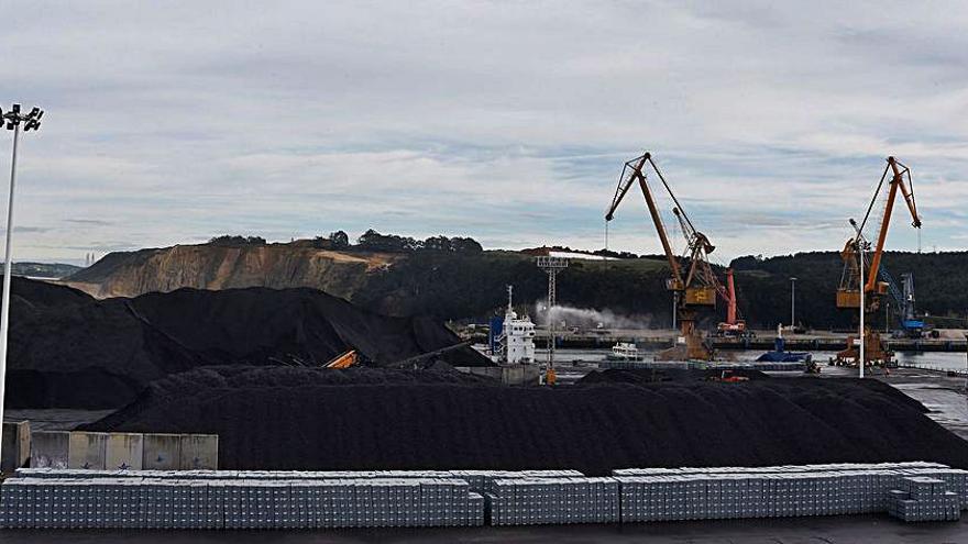 Pilas de cinc, en primer término, y de carbón en el muelle de Raíces. | R. Solís