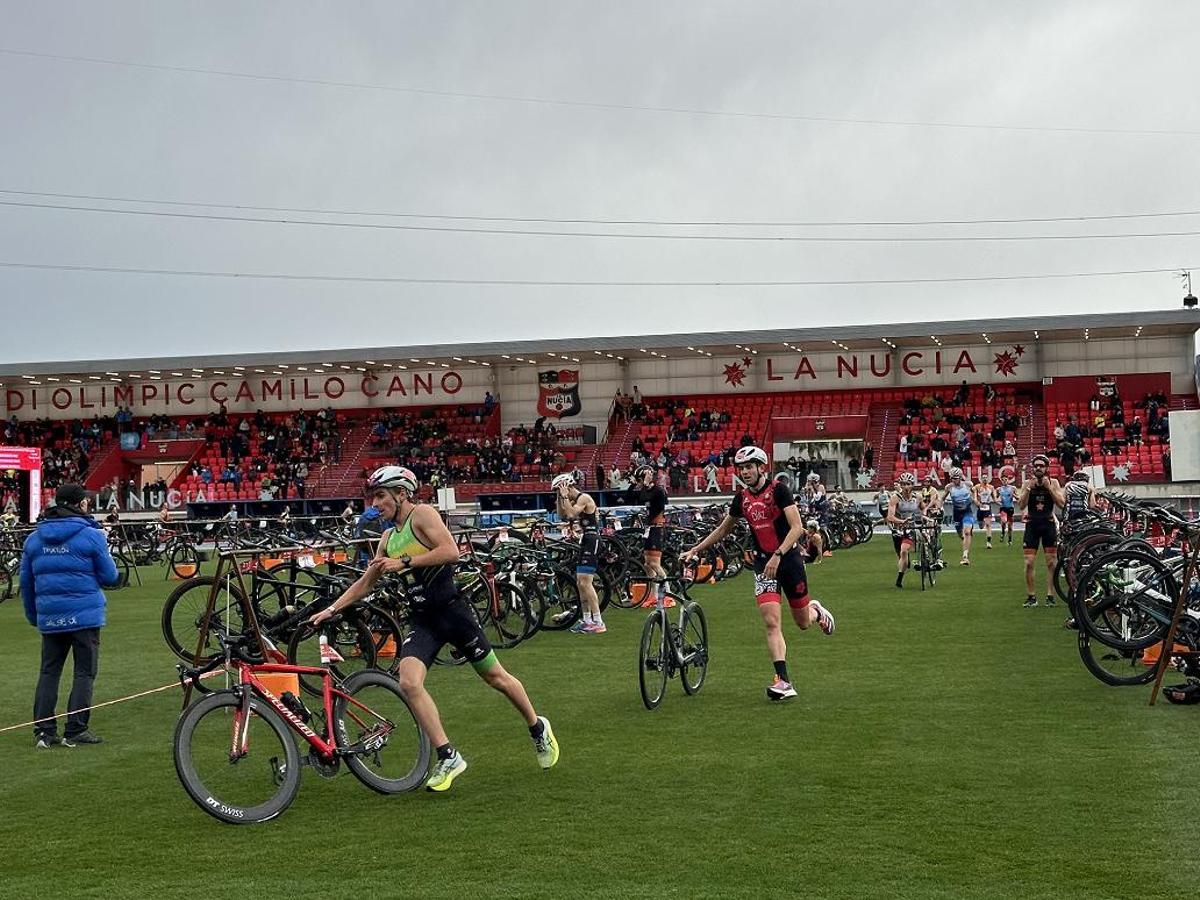 Los participantes realizan la transición de carrera a bici en el Estadi Olímpic Camilo Cano