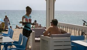 Una camarera en un chiringuito de playa trabajando durante el verano, en Badalona