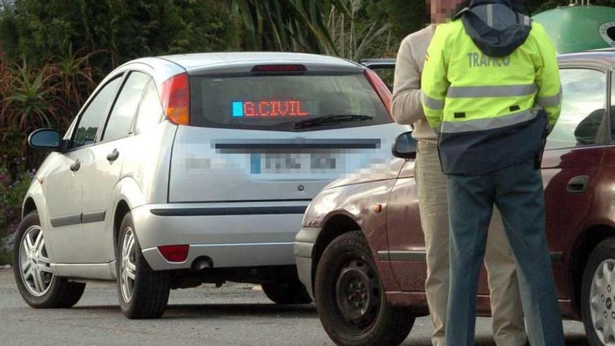 Un agente con un conductor tras ser interceptado por un coche camuflado de la Guardia Civil.