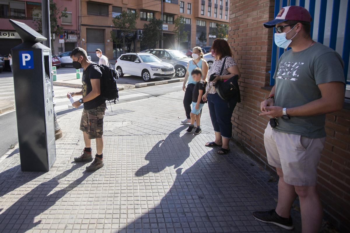 Cola en un parquímetro de la zona azul, para pagar.