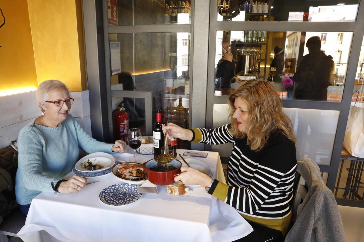Dos mujeres disfrutando de las jornadas gastronómicas del Antroxu en El Llar de la Catedral