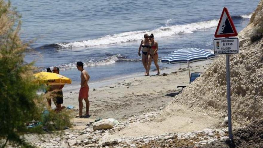 Los bañistas siguen paseando por la zona prohibida de la playa de l&#039;Almadrava y plantando las sombrillas pese a las señales de peligro.