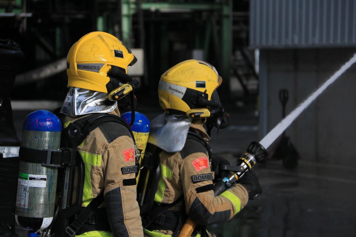 Dos bombers de la Generalitat treballant en un incendi, en una foto d'arxiu