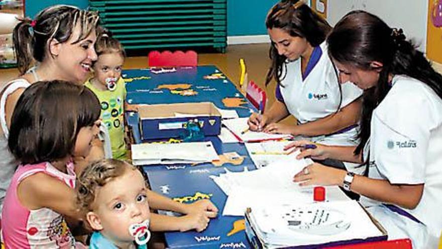 Niños menores  de tres años  asisten junto con sus padres a su primer día de guardería.