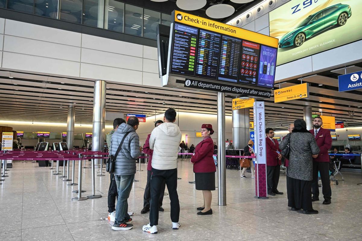 Los empleados de Qatar Airways ayudan a los pasajeros con sus preguntas en la zona de facturación del Aeropuerto de Londres-Heathrow, debido a la grave interrupción de los vuelos tras los ataques de Estados Unidos e Israel contra Irán.