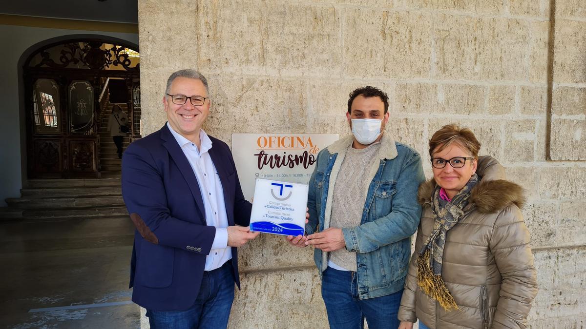 Prada (izquierda) entrega a Del Bien y una trabajadora de Turismo la placa