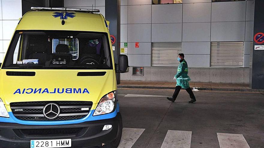 Un sanitario camina junto a una ambulancia en las inmediaciones del Hospital Universitario de A Coruña.