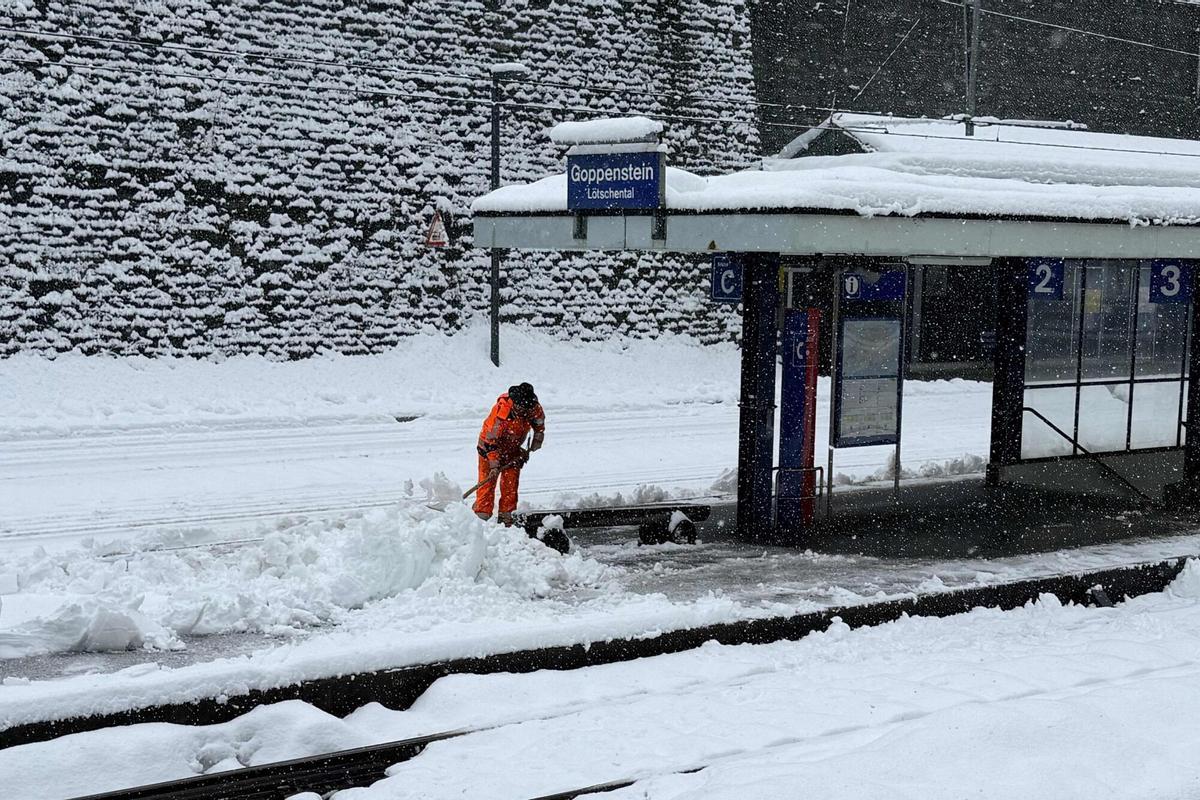Un empleado limpia la nieve del ferrocarril después de una fuerte nevada, que causó el descarrilamiento de un tren regional, en la estación de Goppenstein, sur de Suiza, el 16 de febrero de 2026.
