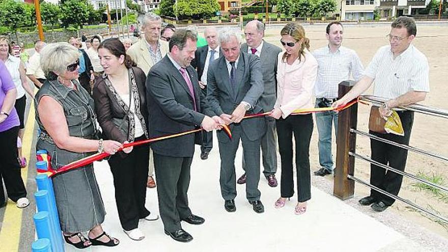 Juan Carlos Martín Fragueiro -quinto por la derecha- y Rogelio Pando cortan la cinta inaugural del paseo marítimo de La Isla.