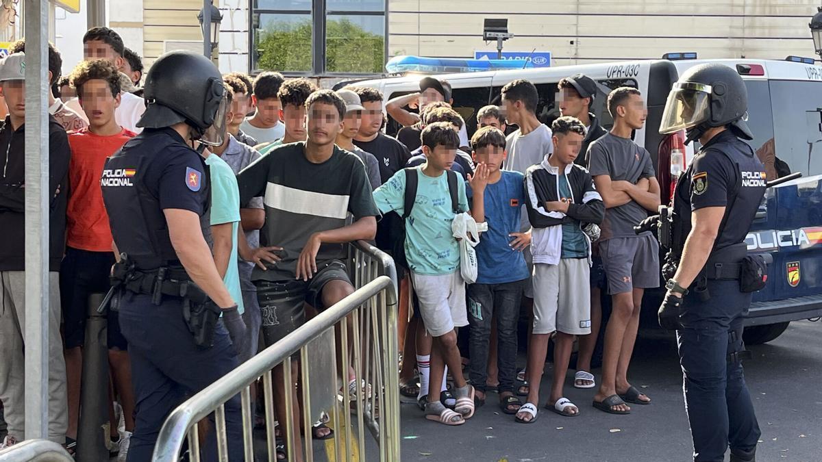 Multitud de menores migrantes esperan para su filiación frente a la Jefatura Superior de la Policía Nacional en Ceuta este lunes.