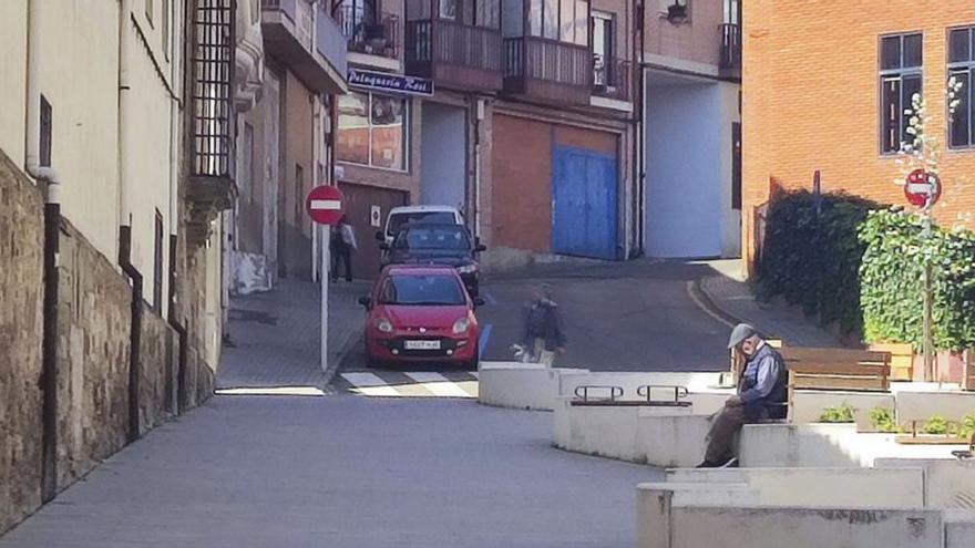 Un mayor descansando en un banco de la Cuesta del Hospital.