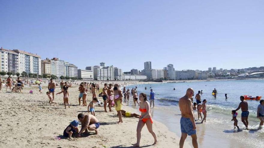 Bañistas en la playa del Orzán.