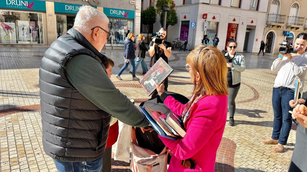 La edil Aurora Rodil entrega un libro a un niño en el centro de Elche este 23 de abril