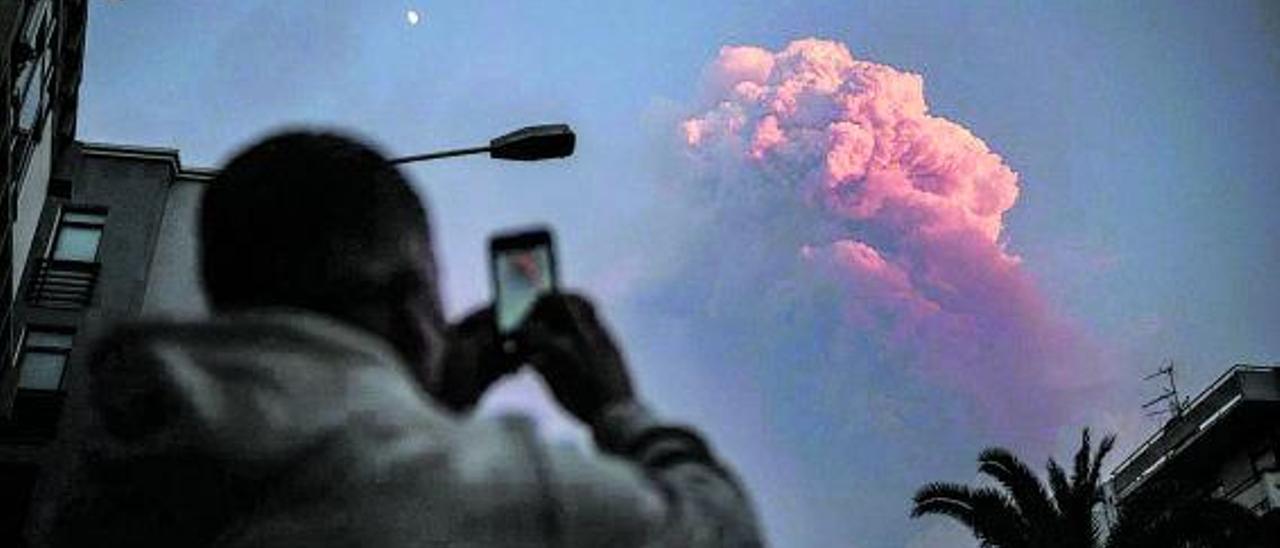 Un vecino del Valle de Aridane hace una fotografía con su móvil a una nube creada por la erupción. | | ANDRÉS GUTIÉRREZ