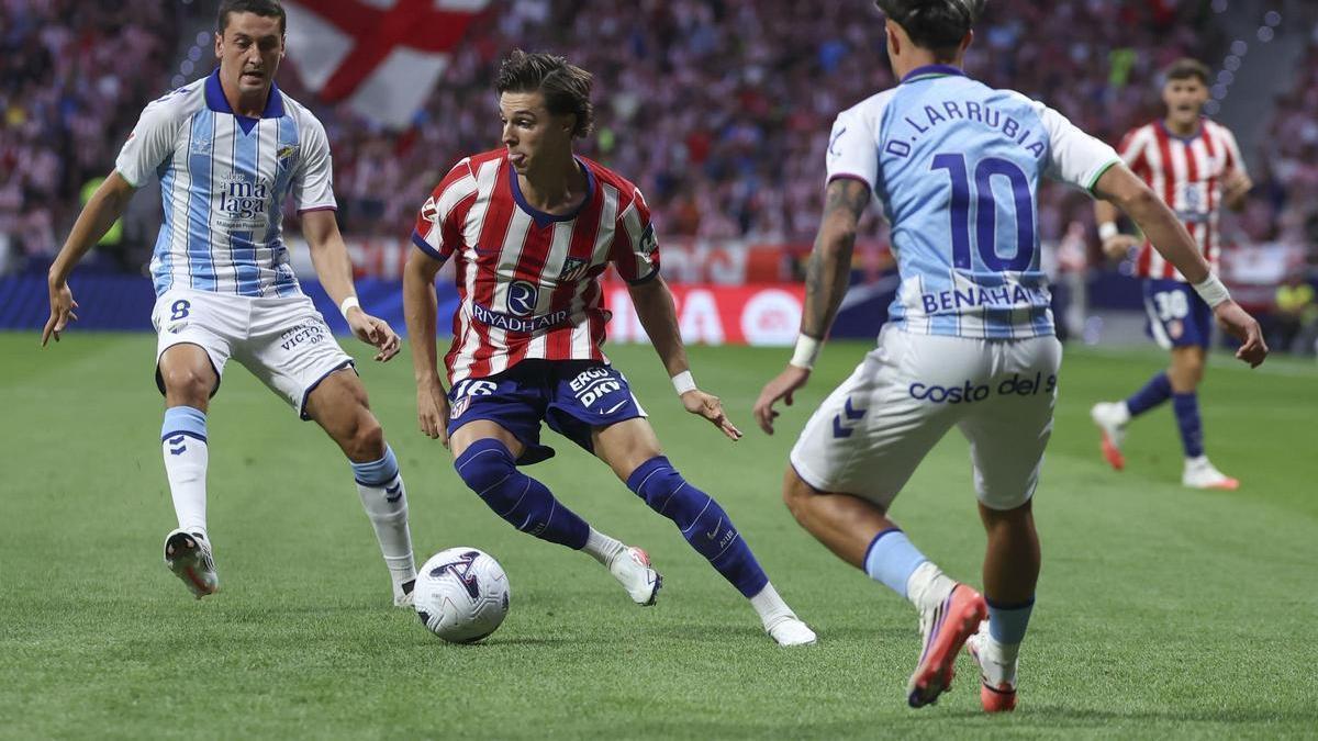 Los jugadores del Málaga intentan frenar el avance del equipo madrileño.