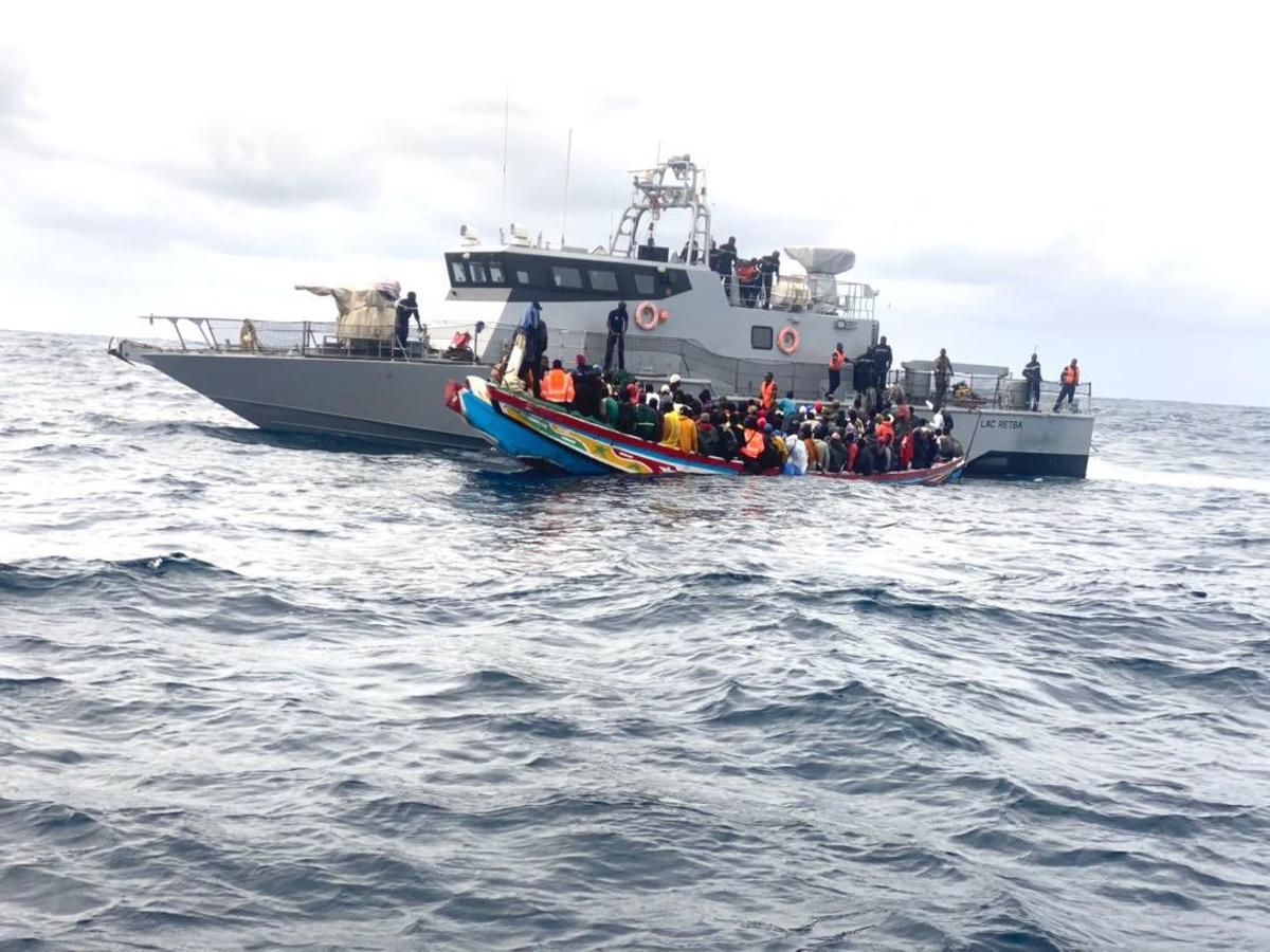 Un barco de la Armada senegalesa junto a un cayuco antes de ser rescatado.