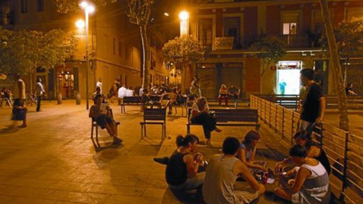 Un grupo de jóvenes cena en el improvisado merendero de la plaza del Diamant, frente a un local de comida para llevar, la semana pasada.